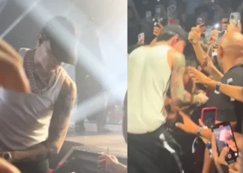 Peso Pluma baja del escenario para cantar con niño con discapacidad